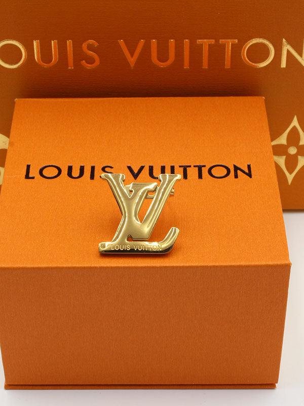 بروش ماركة لويس فيتون وسط بروش louis vuitton ذهبي 